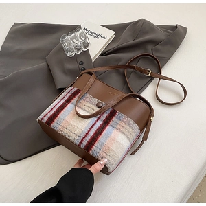 Détail du tweed à carreaux rétro et cuir marron sur un grand sac à bandoulière