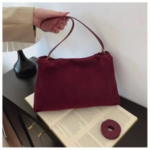 Close-up of burgundy suede Boston bag featuring matching wide strap and adjustable shoulder strap