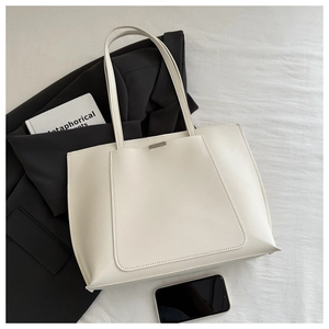 Detail shot of the cream white tote bag featuring PU leather texture and silver buckle