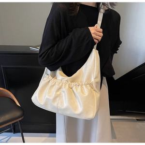 Detail einer minimalistischen cremeweißen Falten-Schultertasche aus weichem PU-Leder