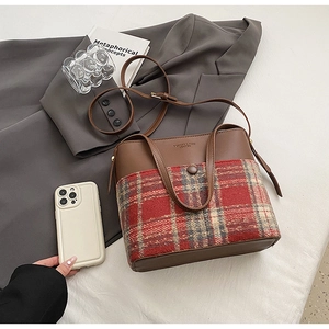 Détail du sac seau vintage avec tissu à carreaux, cuir marron et bandoulière réglable