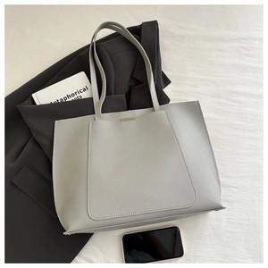 Detailed top view of light gray minimalist tote bag with smartphone and urban props