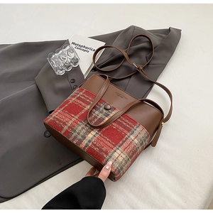 Gros plan d'un sac seau rétro à carreaux avec garniture en cuir PU brun et bouton vintage