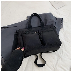 Top view of a black multi-pocket utility tote bag with sturdy woven straps and metal zippers