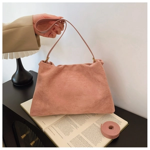 Detail of dusty pink suede Boston bag featuring soft texture and dual strap options