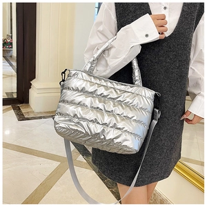 Close-up of metallic silver quilted puffer tote bag with adjustable shoulder strap