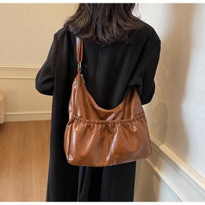 Nahaufnahme der braunen Handtasche aus Kunstleder mit Falten und großem Stauraum