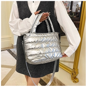 Detail view of silver padded tote bag with horizontal quilting and long nylon strap