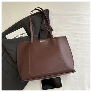 Macro shot of dark brown tote bag texture with rectangular stitching and silver buckle