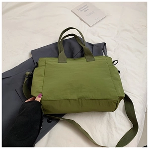 Detail view of military green nylon tote bag with side pockets and adjustable strap