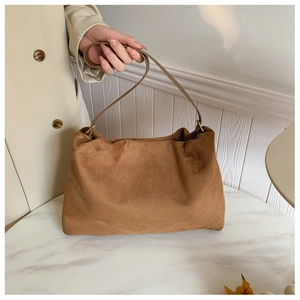 Detailed view of brown matte leather shoulder bag with vintage gold metal buckles