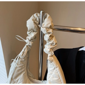 Close-up of puffy ruffled shoulder strap and nylon fabric detail on winter shoulder bag