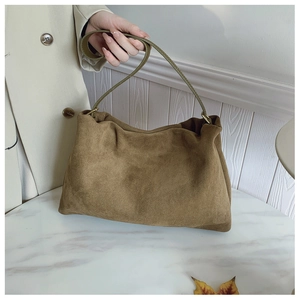 Detail of brown suede Boston bag showing soft texture and fine gold hardware details