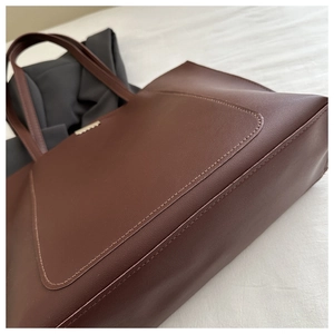 Close-up of dark brown tote bag showing fine leather texture and neat stitching details