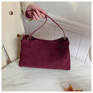 Detail of burgundy suede leather Boston bag with premium gold metal ring hardware