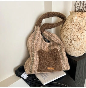Detailed view of plush lamb-like knit tote bag with brown straps and striped texture