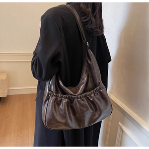 Detailansicht der Faltenstruktur und des großen Designs dieser dunkelbraunen Hobo-Tasche
