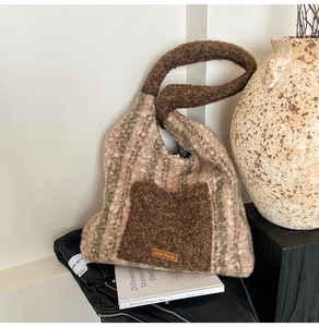 Detail of plush tote bag with striped texture and leather logo on brown front pocket