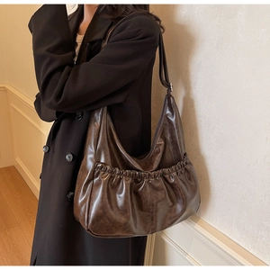 Detail der braunen Retro-Hobo-Tasche mit Falten und verstellbarer silberner Schnalle