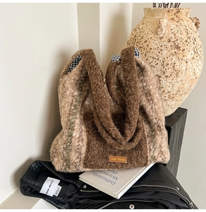 Close-up of plush faux shearling tote bag with contrasting colors and orange logo patch