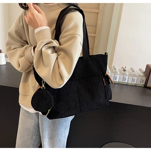 Large black corduroy tote bag with small round pouch shown on a casual outfit