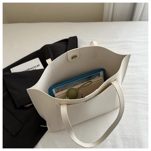 Detail view of a spacious ivory white tote bag showing organized interior storage space
