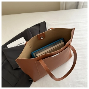 Top view of brown tote bag showing spacious interior with tablet and laptop storage