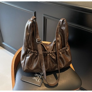 Detailansicht der dunkelbraunen Retro-Ledertasche mit Seitenfalten und Trageriemen