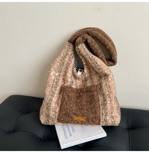 Detailed view of plush checkered tote bag with fuzzy front pocket and brand leather label