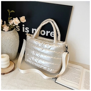 Detailed macro view of champagne quilted down tote bag with a soft padded top handle
