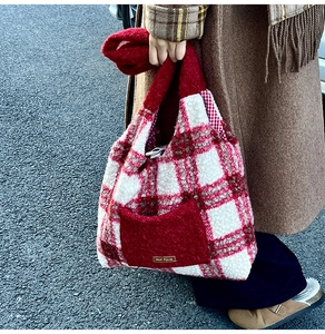 Detail of red and white checkered plush tote bag featuring soft faux shearling texture