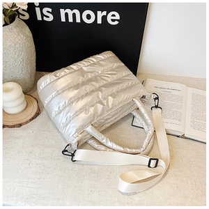 Detailed close-up of champagne silver metallic quilted tote with detachable strap and zipper