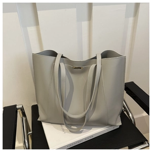 Detail shot of light grey tote bag showing fine stitching and minimalist gold hardware