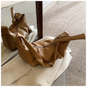 Detail view of brown soft leather hobo bag with knotted strap and zipper closure