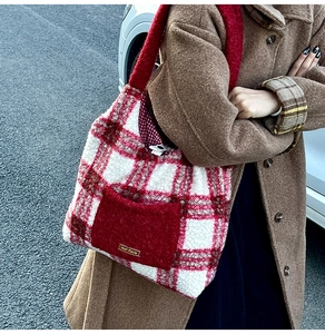 Detail shot of plush red and white plaid tote bag featuring a solid red front pocket