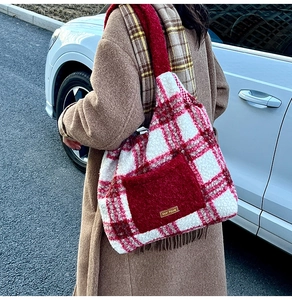 Detailed texture of red plaid plush tote bag with cozy fleece finish and front pocket