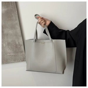 Detail view of grey large capacity tote bag with dual handles and metal accent