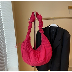 Close-up of quilted fuchsia hobo bag featuring a unique scrunchie-style shoulder strap