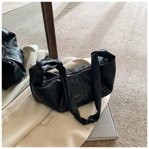 Detail of soft black pleated leather shoulder bag with decorative knotted strap and zipper
