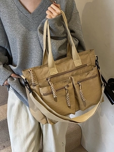 Large khaki multi-pocket tote bag with adjustable shoulder strap and woven zipper details