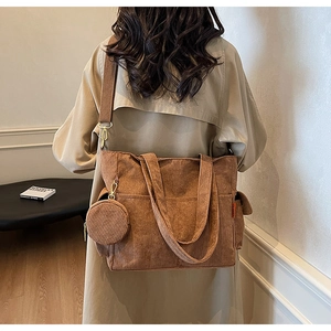 Detail of a brown corduroy tote bag with vertical texture and matching small round pouch