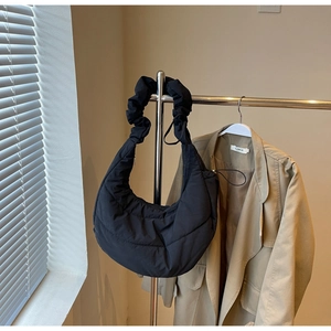 Detail of black quilted puffer hobo bag with unique scrunchie strap and puffy texture