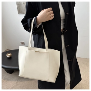 Minimalist white tote bag with elegant golden hardware and front pocket detail