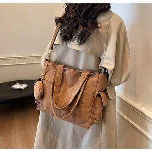 Detail of tan corduroy tote bag showing side pocket, coin purse and metal strap buckle