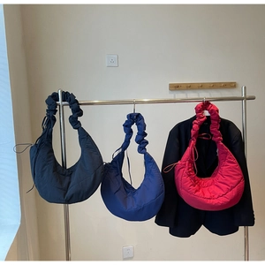 Close-up of quilted nylon crescent bags in black, royal blue and rose pink colors