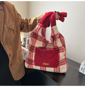 Detail shot of plush red checkered tote bag with furry pocket and our fave leather label