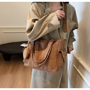 Detail of brown corduroy tote bag showing large capacity, side pocket and small round pouch