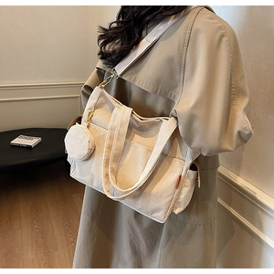 Detail of off-white corduroy tote bag with small coin purse and adjustable wide shoulder strap