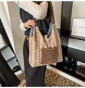 Close-up detail of the plush striped tote bag featuring a contrast pocket and brand tag