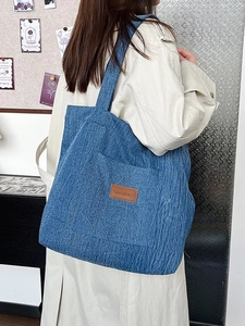 Blue corduroy canvas tote bag with adjustable strap and front pocket for women